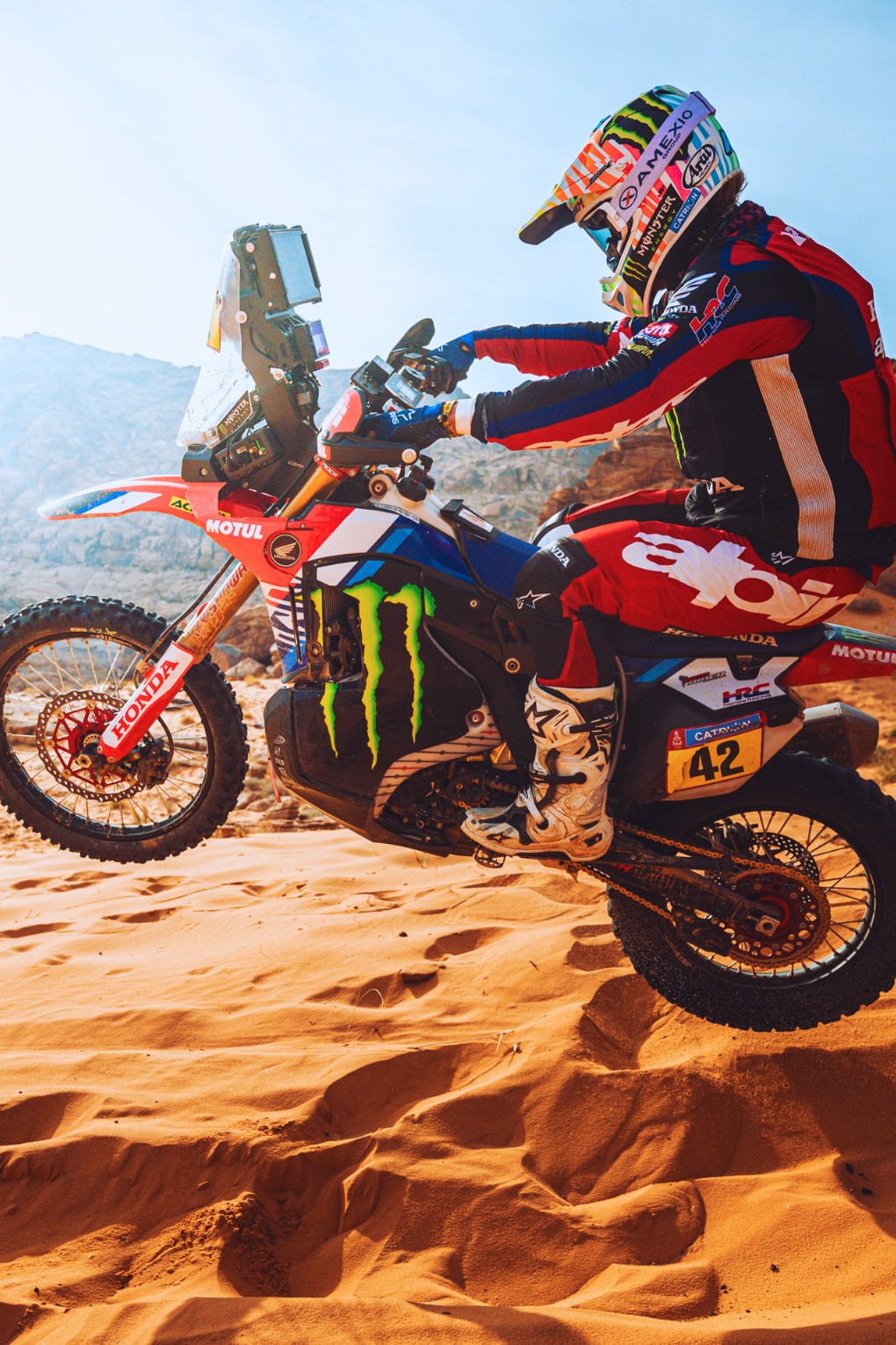 Adrien Van Beveren en plein saut lors du Dakar, moto en suspension au-dessus du sol