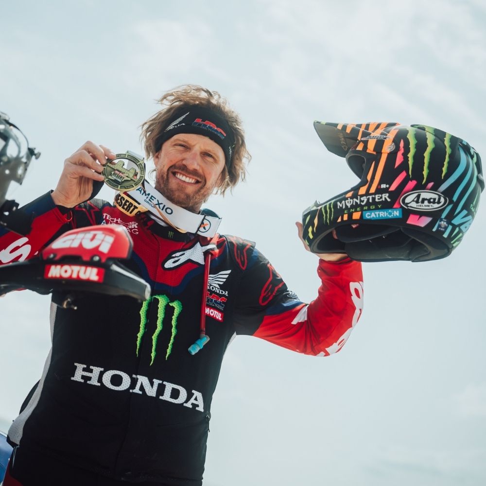 Adrien Van Beveren avec son casque Arai original Zebra noir et fluo après sa victoire à l’Abu Dhabi Desert Challenge, casque moto rallye-raid porté en course.