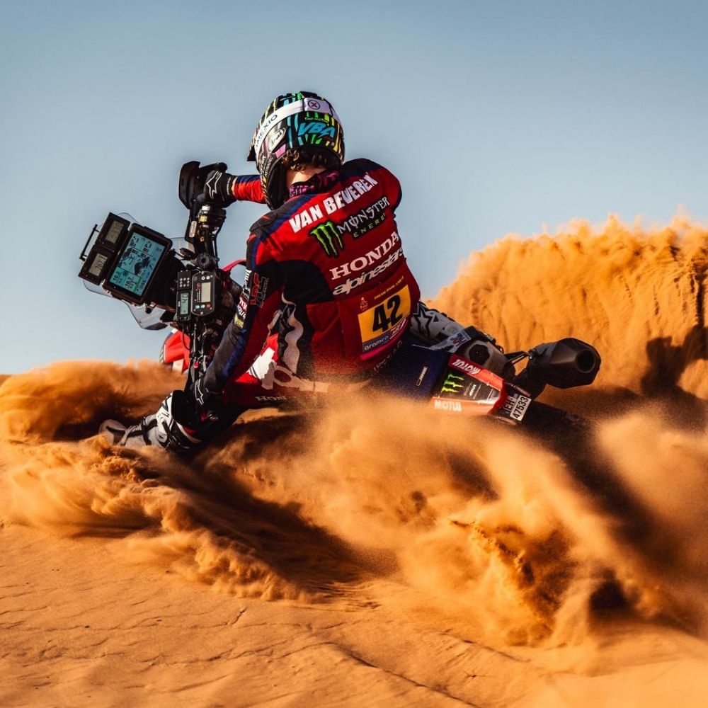 Adrien Van Beveren en action dans le désert, moto penchée dans un virage serré lors d’un rallye-raid, casque porté en course.