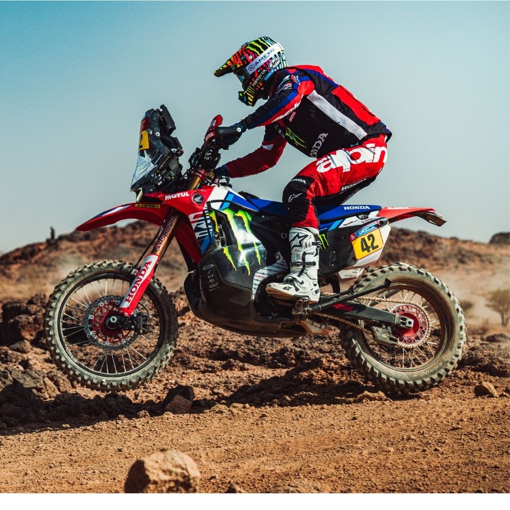 Adrien Van Beveren en action lors d’une épreuve du World Rally-Raid Championship dans un désert caillouteux, en équilibre et en plein contrôle sur sa moto.